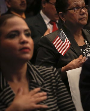 New U.S. citizens pledge the Oath of Allegiance during a naturalization ceremony at the New York last month. AP PHOTO BY BEBETO MATTHEWS