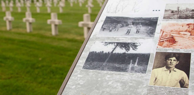 In this photo taken on Wednesday, June 8, 2016, an information board with a photograph of Alan Seeger guides visitors through the French National Necropolis of Lihons, in Lihons, France. American poet Alan Seeger died a century ago on July 4th during the 1916 Battle of the Somme in northern France, already fighting for a global, common cause that bound dozens of countries together at a time when the United States was still a bystander, reluctant to get involved in a faraway war. (AP Photo/Virginia Mayo)