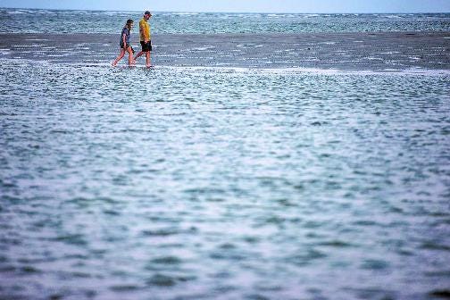 FILE - A couple walks along a sandbar on the south end of Tybee Island during low-tide. (Josh Galemore/Savannah Morning News)