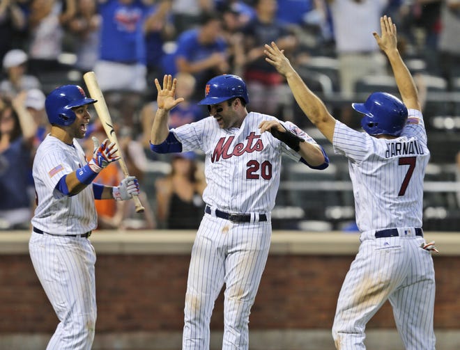 Mets' Neil Walker, center, and Travis d'Arnaud, right, celebrate scoring on a double by Yoenis Cespedes with teammate James Loney, left, during the eighth inning. The Associated Press