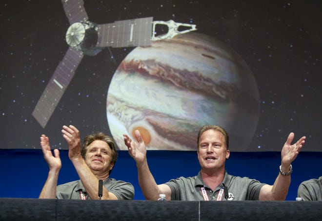 Scott Bolton, left, and Rick Nybakken are seen in a post-orbit insertion briefing at NASA's Jet Propulsion Laboratory following the solar-powered Juno spacecraft entered orbit around Jupiter on Monday, July 4, 2016, in Pasadena, Calif. (AP Photo/Ringo H.W. Chiu)