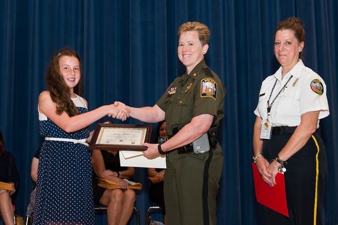 Chesterfield County Police Maj. K.C. Carr, center, and Child Safety Officer Diane Pongallo, right, present Grange Hall Elementary School student, Ashley Henderson, this year's Craig Rath Memorial Scholarship. Contributed Photo