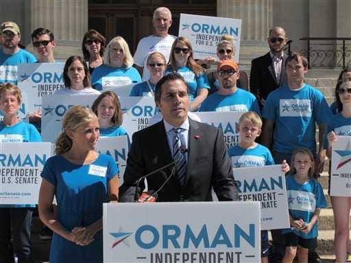 In this July 28, 2014, file photo, Greg Orman, right, an independent candidate for the U.S. Senate in Kansas, discusses his campaign during a news conference, as his wife, Sybil, watches to his left.