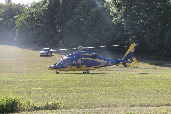 A University of Michigan Survival Flight helicopter touches down in an open field just down the road from the crash. COREY MURRAY PHOTO