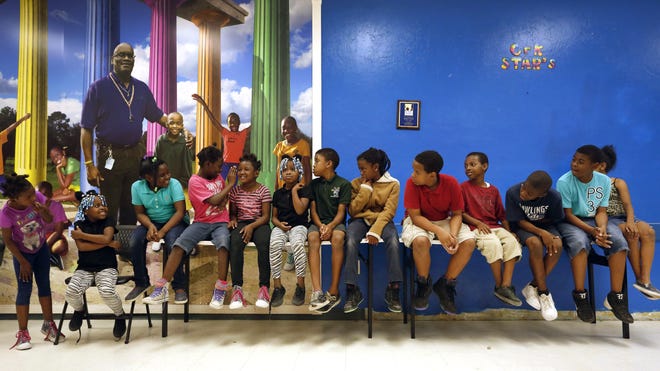 After-school youth play a game of "Telephone," whispering secrets to one another, while at the Clarence R. Kelly Community Center, known more commonly as the Blue Center. Erica Brough/Special to the Guardian