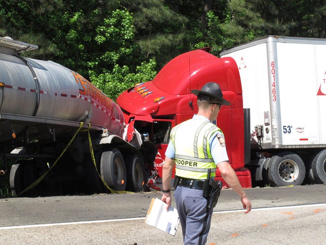 File- This April 22, 2015, file photo shows a Georgia state trooper working the scene of a deadly crash in which five people died and three others were injured in Ellabelle, Ga. A southeast Georgia prosecutor said Wednesday, July 6, 2016, that he has dropped the criminal case against a trucking company charged in a fiery interstate crash last year that killed five nursing students. District Attorney Tom Durden of Georgia's Atlantic Judicial Circuit said he made the decision after Total Transportation of Mississippi agreed to spend $200,000 setting up a nonprofit group offering nursing students financial aid. A grand jury indicted the company in June on charges of vehicular homicide and other crimes related to the deadly crash. (AP Photo/Russ Bynum, File)