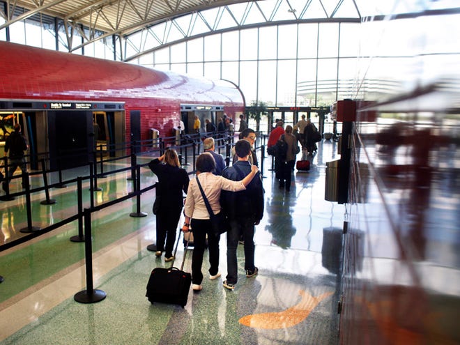 Passengers walk to board the tram at Airside F upon their arrival at TIA on January 5, 2012. (Archive photo / Tampa Bay Times)