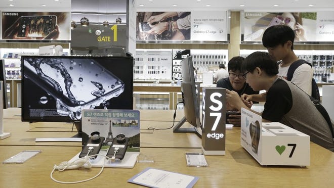 Middle school students try out Samsung Electronics' Galaxy S7 Edge smartphones at the company's showroom in Seoul, South Korea, Thursday, July 7, 2016. Samsung Electronics said Thursday that its second-quarter operating income jumped 17 percent over a year earlier to the highest quarterly profit in more than two years, as strong sales of its Galaxy smartphones drove profit growth in the mobile business.(AP Photo/Ahnn Young-joon)