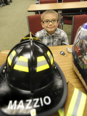 Dominic Mazzio, 5, sits with his fire gear at the Burlington Township Fire Commissioners meeting, where he became an honorary member of the Fire Department.