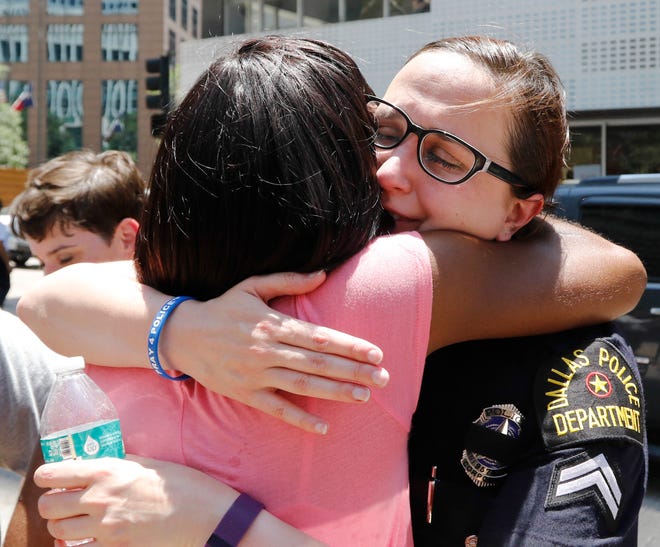 Dallas Police officer D. Webb, right, receives a hug after a citywide prayer service in downtown Dallas on Friday, July 8, 2016, following the shootings during a peaceful protest on Thursday, which left five police officers dead.