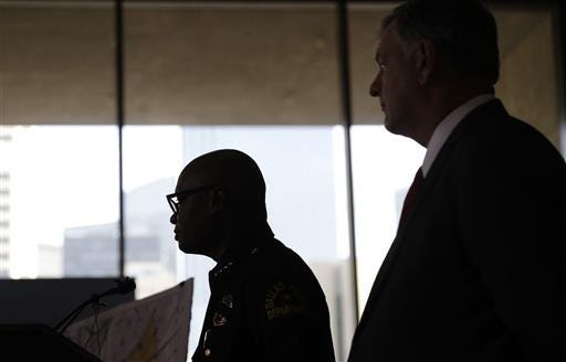 Dallas police chief David Brown, left, and Dallas Mayor Mike Rawlings talk with the media during a news conference on Friday.