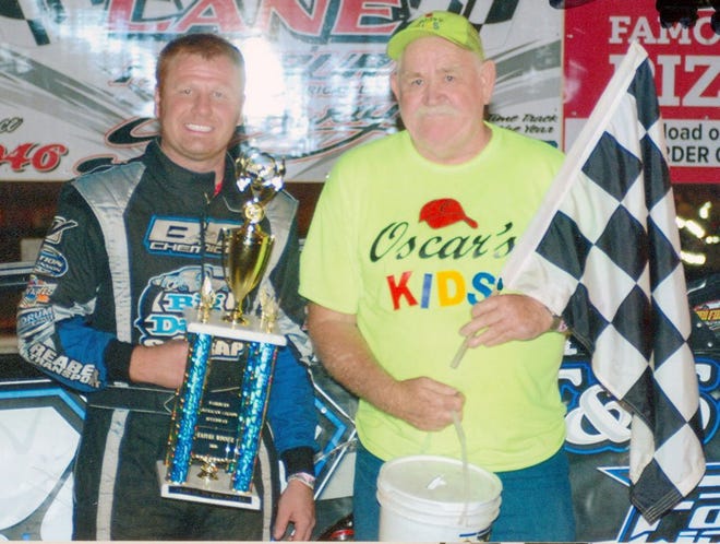 Driver Mike Spatola III, left, donated $800 to Oscar Gorbet for the Muscular Dystrophy Association's Central Illinois Chapter and allowed him to hold the checkered flag after Spatola's feature win on June 4.