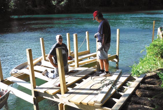Workers assemble a new dock at the Voyager Island Park site.