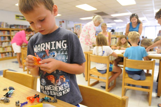 Mac Millis puts together an action figure as he takes part in New Hanover County's Summer Reading program at Blair Elementary School on July 6, 2016 in Wilmington.