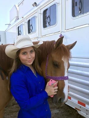 Cami Alderson and her horse, Detroit, pose in front of their trailer. Alderson, a 16-year-old Rock Bridge student, is seventh in the Missouri Rodeo Cowboy Association rankings in barrel racing.