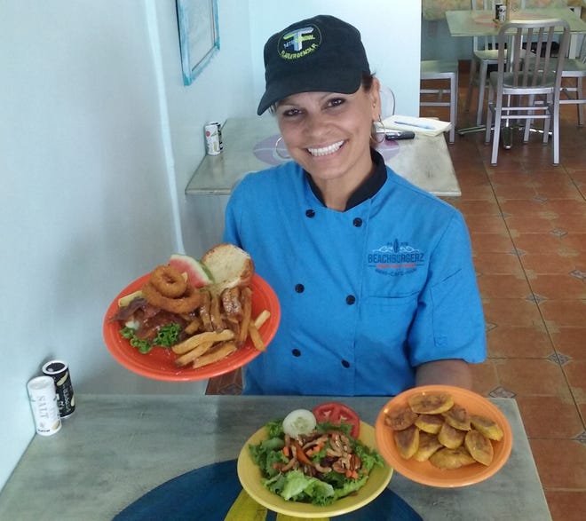 BeachBurgerz kitchen manager Laura Lozada sets a table with the restaurants' special Bonfire BBQ Bourbon Burger, Handcut House Friez, plantains and Farmer's Market Salad. NEWS-JOURNAL/SHAUN RYAN