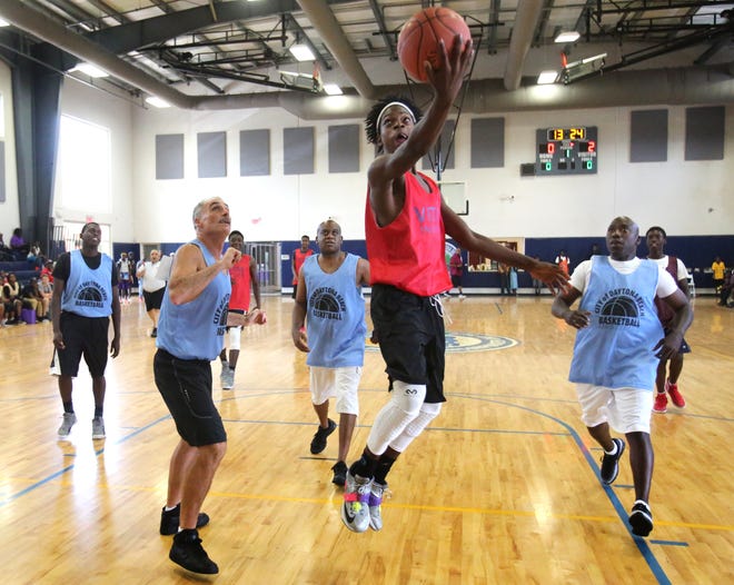 Where's the defense? Brieon Bean blows by Daytona Beach Police Chief Mike Chitwood, Mayor Derrick Henry and other police officers for an easy layup at the Midtown Cultural and Education Center in Daytona Beach on Saturday. News-Journal/NIGEL COOK