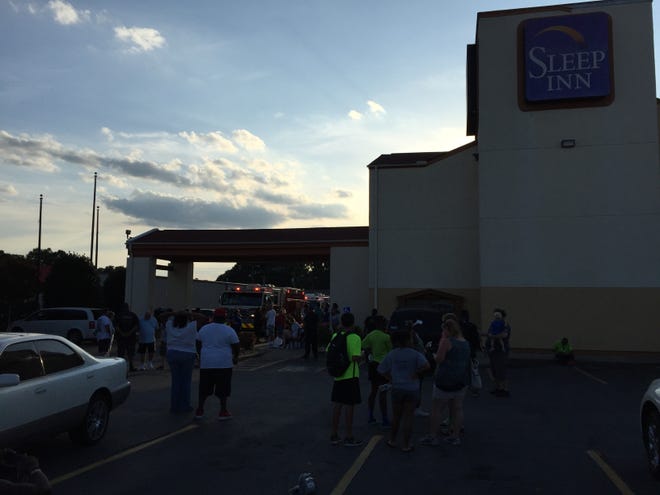 Sleep Inn guests wait in the parking lot Saturday evening after the hotel was evacuated following an explosion on the third floor.