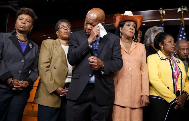 Civil right leader Rep. John Lewis, D-Ga., center, wipes his eyes as members of the Congressional Black Caucus make emotional statements condemning the slayings of police officers in Dallas last night, and the fatal police shootings of black men in Louisiana and Minnesota earlier in the week, during a news conference on Capitol Hill in Washington, Friday, July 8, 2016. From left are: Rep. Barbara Lee, D-Calif., Rep. Marcia L. Fudge, D-Ohio, Rep. John Lewis, D-Ga., Rep. Frederica Wilson, D-Fla., and Rep. Sheila Jackson Lee, D-Texas. (AP Photo/J. Scott Applewhite)