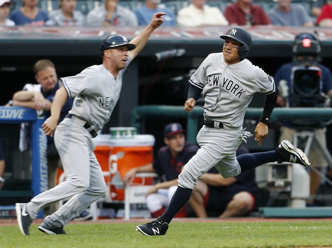 New York Yankees' Ronald Torreyes (17) gets waved home by third base coach Joe Espada to score the game winning run against the Indians on Saturday. AP Photo
