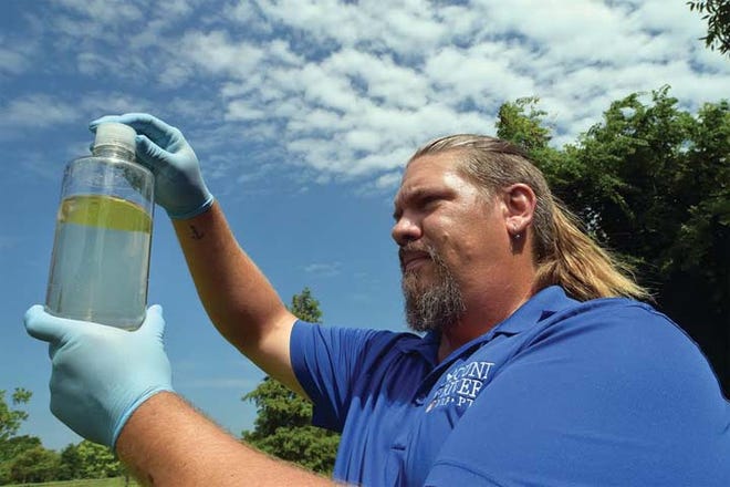 Travis Graves looks at a water sample, which while rather clear in appearance, will go to a lab in Greenville for testing.