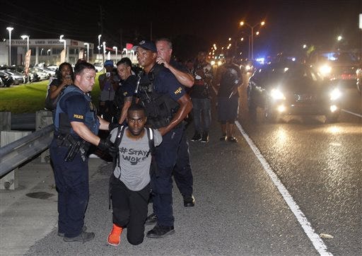 Police arrest activist DeRay McKesson during a protest along Airline Highway, a major road that passes in front of the Baton Rouge Police Department headquarters Saturday, July 9, 2016, in Baton Rouge, La. Protesters angry over the fatal shooting of Alton Sterling by two white Baton Rouge police officers rallied Saturday at the convenience store where he was shot, in front of the city's police department and at the state Capitol for another day of demonstrations. (AP Photo/Max Becherer)