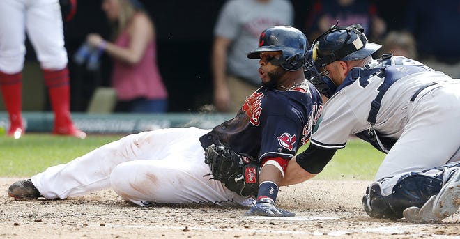 The Indians' Carlos Santana is tagged out at home plate by the Yankees' Brian McCann during the third inning.