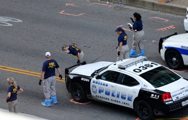 An FBI evidence response team works the crime scene, Sunday, July 10, 2016, where five Dallas police officers were killed Thursday, in Dallas. A peaceful protest over the recent videotaped shootings of black men by police turned violent Thursday night as gunman Micah Johnson shot at officers, killing five and injuring seven, as well as two civilians. (AP Photo/Gerald Herbert)