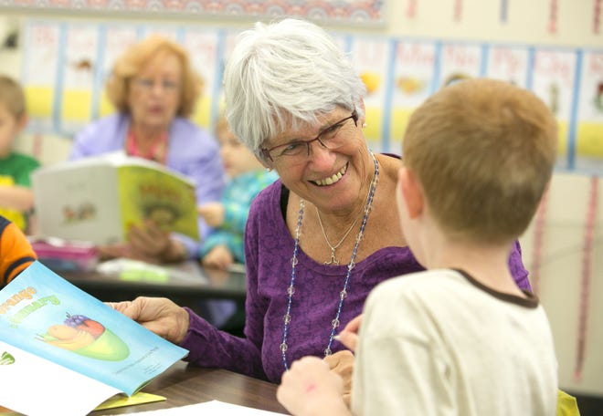 In this Feb. 15, 2016 file phot, Reading Pal Judie Betz reads to kindergartners at Belleview-Santos Elementary School in Belleview. The school will be adding an extra hour of reading instruction.