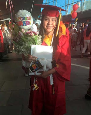 In this May 21, 2016 photo provided by Jessica Barcenas, Ivonne Barcenas Garcia poses in her cap and gown after her high school graduation held at the University of Georgia's Stegeman Coliseum in Athens, Ga. Growing up in Athens, Ivonne Barcenas, 18, had hopes of attending the University of Georgia. But a state law prohibits immigrants without permanent legal status from attending top public universities. Barcenas, whose family came from Mexico when she was 3, is among dozens of students awarded a private scholarship to attend Eastern Connecticut State University in the fall. The scholarship program helps immigrants from states with policies like Georgia's to attend and pay for college. (Jessica Barcenas via AP)