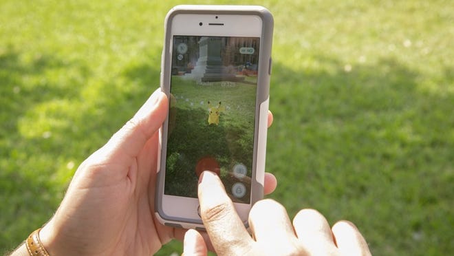Sarah Boutwell captures the Pokemon character Pikachu while playing augmented reality mobile game Pokemon Go at the Capitol Monday July 11, 2016.