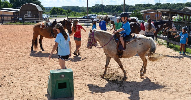 Children get ready for a riding lesson at the DreamCatcher Horse Ranch & Rescue Center on Tuesday, July 12, 2016 in Clermont, Fla. The ranch hosts weekly summer camps to raise money to tend to the rescue horses and teaches children how to ride, groom and maintain the stalls of the horses. (Amber Riccinto/ Daily Commercial)
