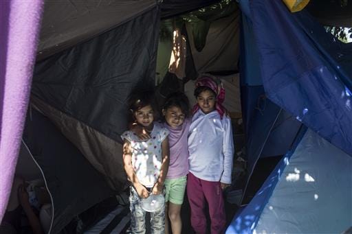 Children stand in a tent inside a migrant camp at Serbia's border with Hungary, in Horgos, Serbia, Monday, July 11, 2016. In what appears to be another refugee crisis in the making in Europe, the numbers are surging at camps on Serbia"™s border with EU country Hungary. The numbers have been growing since last week, when Hungary introduced forced deportations of migrants caught within 8 kilometers (5 miles) of border fences. (AP Photo/Marko Drobnjakovic)