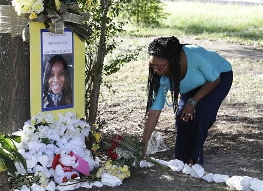Jeanette Williams places a bouquet of roses at a memorial for Sandra Bland near Prairie View A&M University on July 21, 2015.