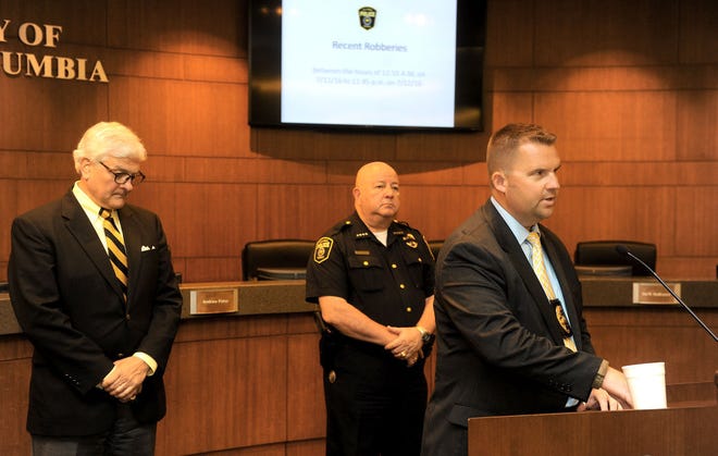 From left, interim MU Chancellor Hank Foley and Columbia police Chief Ken Burton listen as Jeremiah Hunter, assistant police chief, speaks Wednesday at City Hall about four armed robberies that happened in a 24-hour period.