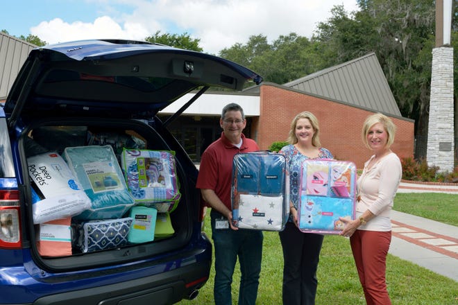 Florida Hospital Fish Memorial chaplain Beth Grant, center, delivered $1,100 worth of bedding items on June 10 to Mark Cobia, left, Florida United Methodist Children's Home manager of marketing and communications; and Elisabeth Gadd, Florida United Methodist Children's Home vice president of development. At the Florida United Methodist Children's Home in Deltona, these donated bedding items will be given to local children, many of whom have never had their own set of sheets or pillow.