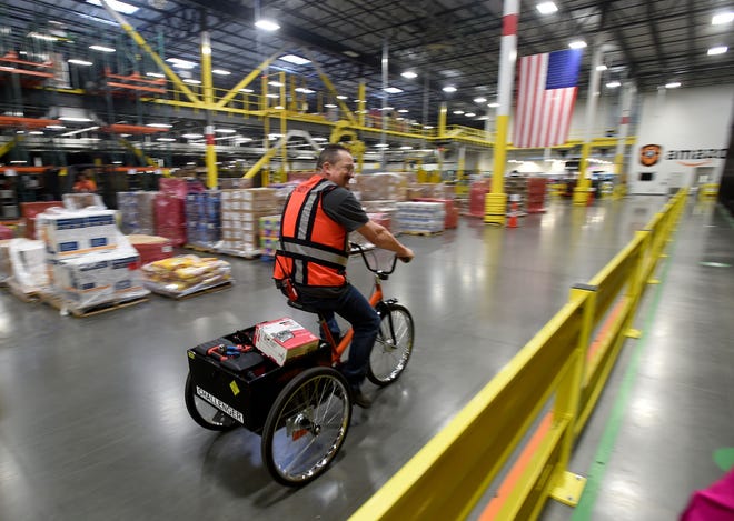 Employees use bicycles to get around the Amazon Fulfillment Center in Lakeland. The company said orders rose 60 percent Tuesday compared with last year's inaugural "Prime Day." GATEHOUSE FLORIDA ARCHIVE / 2015
