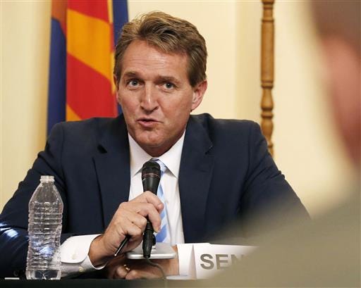 Sen. Jeff Flake, left, R-Ariz., speaks during a2015 field hearing in Phoenix. A large number of GOP senators are skipping next week's convention in Cleveland, citing a range of prior commitments, from fly-fishing to lawn-mowing. Although a majority of the Republican senators do plan to attend, the level of absenteeism is high as Donald Trump prepares to claim the Republican Party's nomination. Flake said he has to mow his lawn.