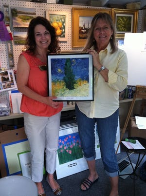 Certified MnemeTherapist Wendi C. Smith, right, and Brienne Cunniff, director of activities at The Pavilion in Hyannis, pose in Smith's studio with 'Autumn Moon,' a painting by Jenks P. that's part of the upcoming Art Without Boundaries exhibition at Cape Cod Art Association. Featured in the show will be paintings by four clients with whom Smith works in private residences, as well as paintings by patients at The Pavilion; Mayflower Place Nursing and Rehab in South Yarmouth; Bridges by Epoch in Mashpee and Hingham; Brookside at Regency in Centerville; and Wingate Residences at Brewster Place. PHOTO BY KAY KEOUGH