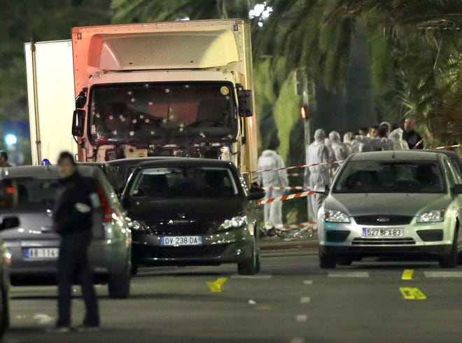 Forensics officers investigate Friday near a truck — its windshield riddled with bullet holes — that plowed through a crowd of revelers who had gathered to watch fireworks Thursday in the resort city of Nice in southern France. At least 84 people were killed before police killed the driver, authorities said.