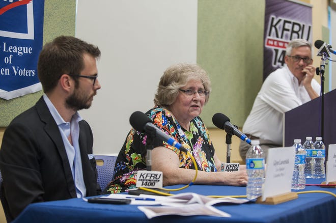 Proposition 1 supporter Jackie Jones, center, delivers her opening remarks while Glyn Laverick, left, listens during a League of Women Voters forum Thursday at the Columbia Public Library.