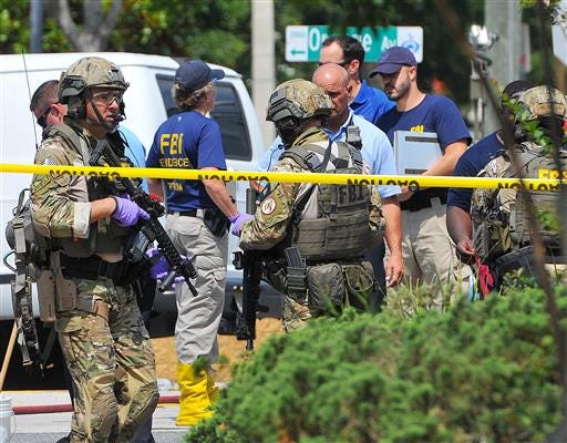 In this June 12, 2016 file photo, FBI, Orlando Police Department and personnel from the Orange County Sheriff's Office investigate the attack at the Pulse nightclub in Orlando, Fla. New reports show that law enforcement officials immediately suspected terrorism and adjusted their staging areas due to fears about an explosive device as they responded to reports of shots fired at the gay nightclub in Orlando. In incident reports released Saturday, June 25, Orange County Sheriff's Office deputies describe receiving limited information about an "active shooter" as they rushed to control the chaos outside Pulse on June 12. (Craig Rubadoux/Florida Today via AP, File)