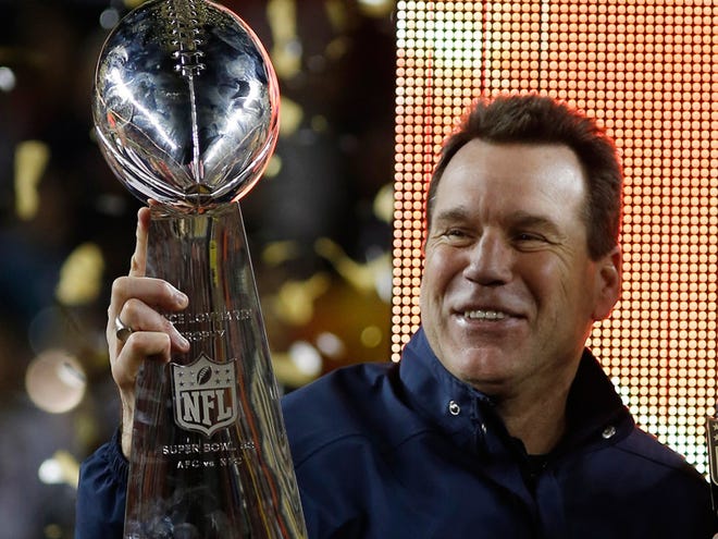 Denver Broncos coach Gary Kubiak holds the trophy after winning the Super Bowl.
