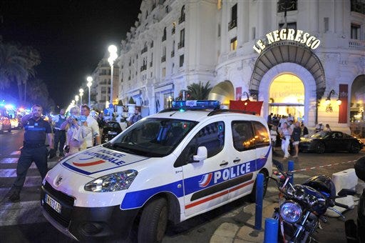 A police car is parked near the scene of an attack after a truck drove on to the sidewalk and plowed through a crowd of revelers who'd gathered to watch the fireworks in the French resort city of Nice, southern France, on Thursday.