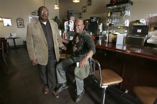 FILE- In this March 5, 2009 file photo, The Rev. W. T. "Dub" Massey, right, and Willie McLeod, left, pose at the counter where they were among the "Friendship Nine" who were jailed during 1960s civil rights "sit-ins" at what is now called the Old Town Bistro, in Rock Hill, S.C. A cellphone app could soon lead drivers to a plantation site in Lake City, the birthplace of jazz trumpeter Dizzy Gillespie in Cheraw and Rosenwald schools across the state. A state commission is developing the app in hopes of encouraging drivers to explore African-American historical sites in rural South Carolina. -(AP Photo/Mary Ann Chastain, File)