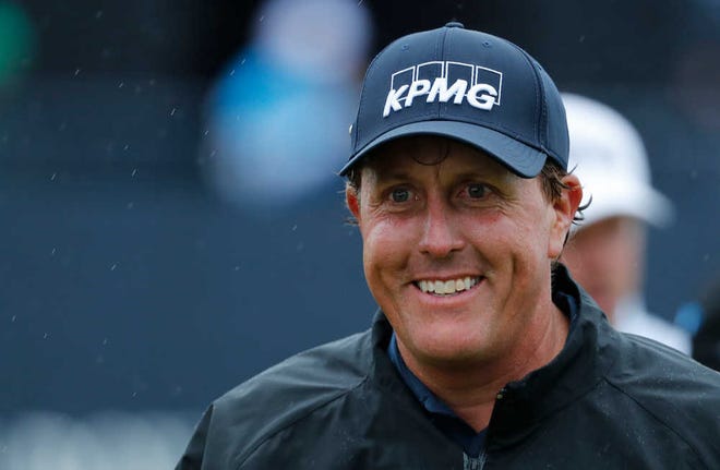 Phil Mickelson smiles as he walks off the 18th green after completing his second round of the British Open in Troon, Scotland, on Friday.
