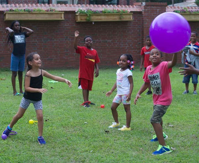 Children play a game with a large ball during Saturday's Colorfest.