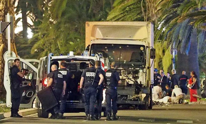 Police stand by as medical personnel attend a person on the ground, right, in the early hours of Friday, July 14, 2016, on the Promenade des Anglais in Nice, southern France, next to the lorry that had been driven into crowds of revelers late Thursday. France has been stunned again as a large white truck killed many people after it mowed through a crowd of revelers gathered for a Bastille Day fireworks display late Thursday evening, in the Riviera city of Nice. (AP Photo)-AP