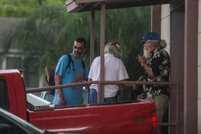 News-Journal reporter Tony Jarmusz takes cover as he hides from a storm while living two days on the streets of Daytona Beach to learn more about life as a homeless man. Jarmusz failed to find shelter on either day. News-Journal/LOLA GOMEZ