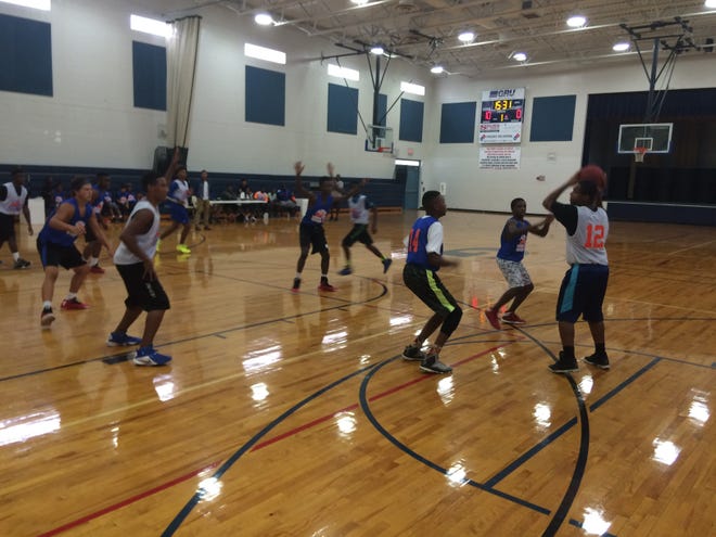 A team from Fort White, in blue jerseys, plays basketball against a team from Newberry during the Summer Heatwave Program. (Cleveland Tinker/Correspondent)